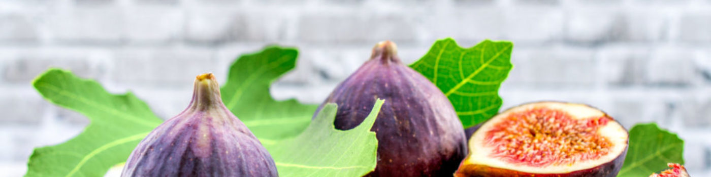 fig fruit on a wooden table with a brick background
