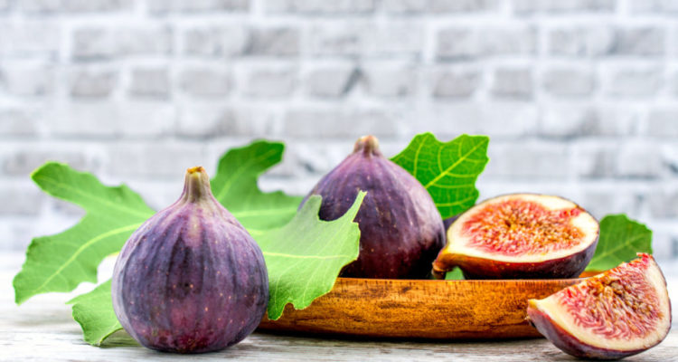 fig fruit on a wooden table with a brick background