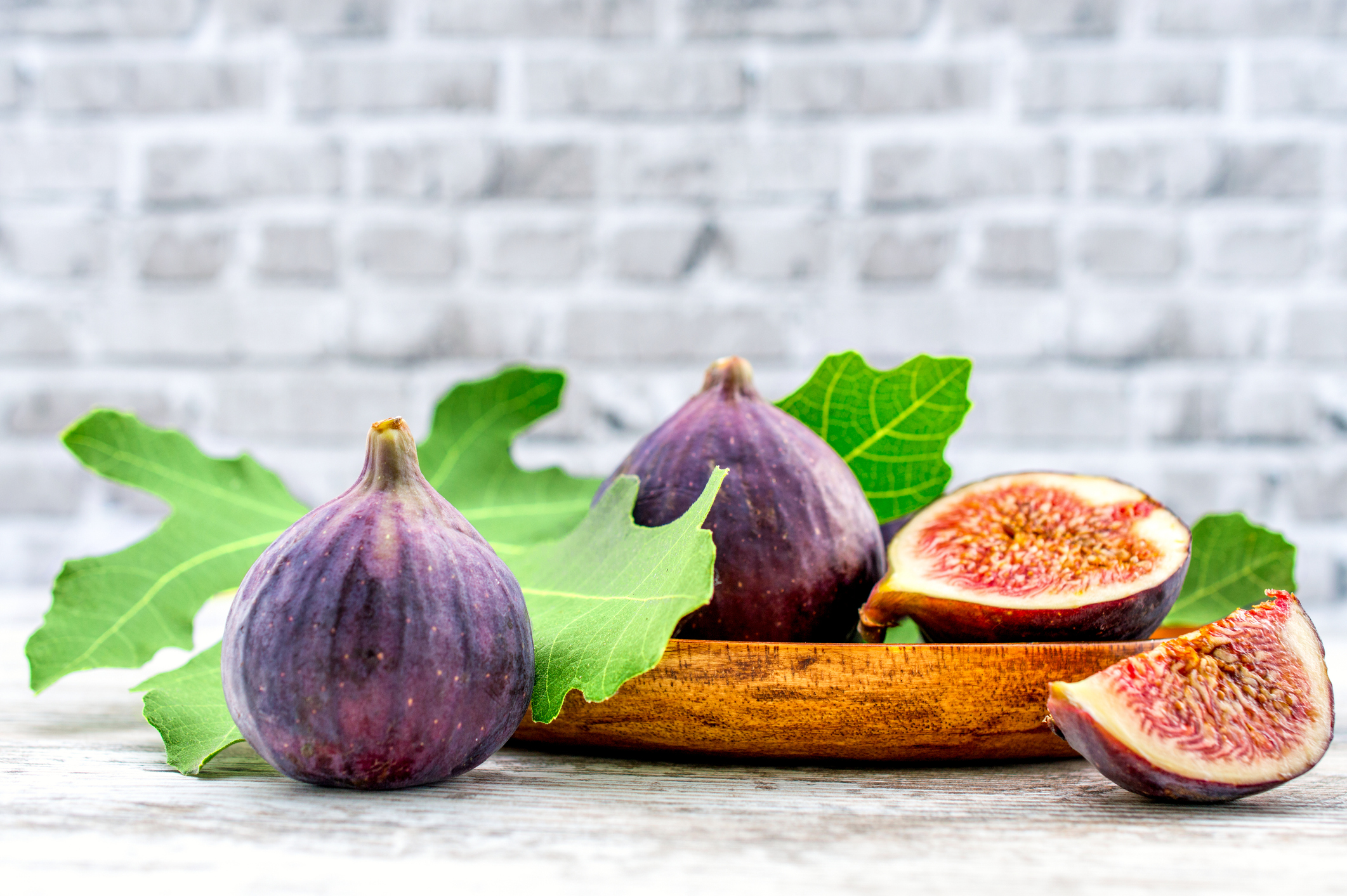 fig fruit on a wooden table with a brick background fig fruit on a wooden table with a brick background